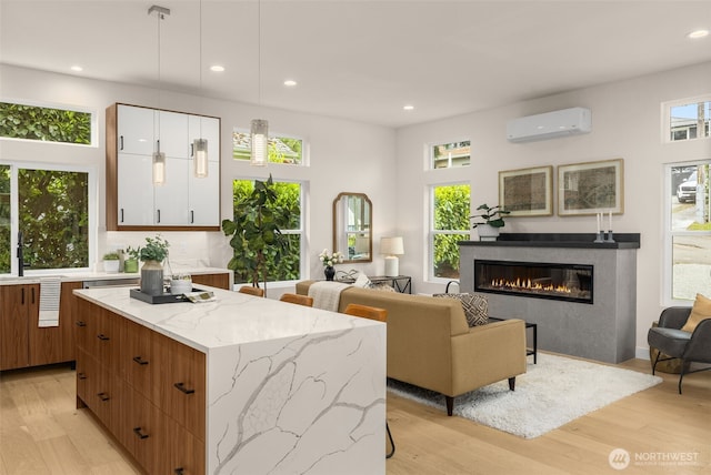 2727 50th Ave SW, Seattle, WA 98116 - living area with a wall mounted air conditioner, light wood finished floors, recessed lighting, and a glass covered fireplace