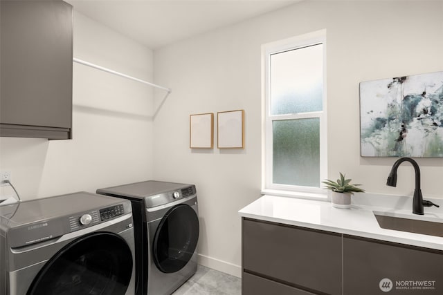 2727 50th Ave SW, Seattle, WA 98116 - laundry area with cabinet space, washing machine and clothes dryer, baseboards, and light tile patterned floors
