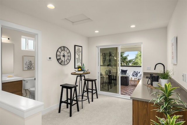 2727 50th Ave SW, Seattle, WA 98116 - kitchen with light colored carpet, plenty of natural light, brown cabinetry, recessed lighting, and baseboards