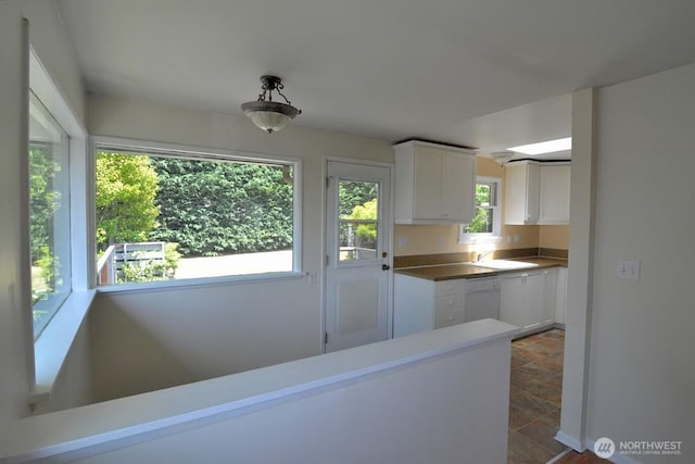 2116 N 86th St, Seattle, WA 98103 - kitchen with white dishwasher, white cabinetry, and dark stone finish flooring