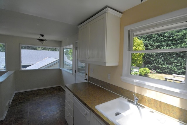 2116 N 86th St, Seattle, WA 98103 - kitchen with healthy amount of natural light, white dishwasher, white cabinets, and dark countertops