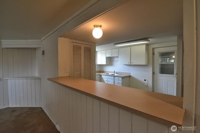 2116 N 86th St, Seattle, WA 98103 - kitchen featuring carpet floors, white cabinets, light countertops, and a peninsula
