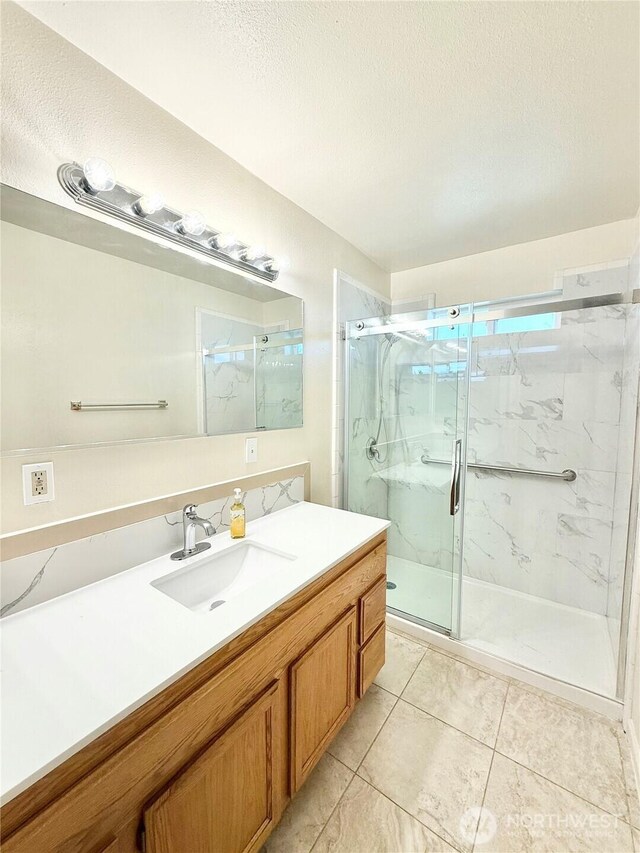 27 Greenacres Rd, Omak, WA 98841 - bathroom featuring a textured ceiling, a marble finish shower, vanity, and tile patterned floors