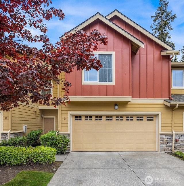 18526 36th Ave W Unit C, Lynnwood, WA 98037 - view of property with a garage, board and batten siding, driveway, and stone siding