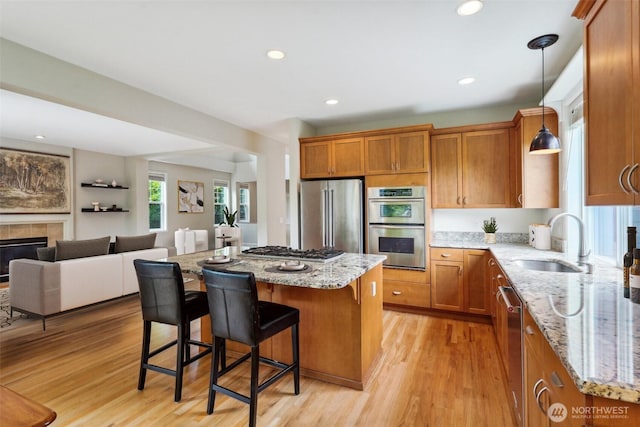 27309 SE 10th Ct, Sammamish, WA 98075 - kitchen with stainless steel appliances, a sink, brown cabinetry, open floor plan, and recessed lighting