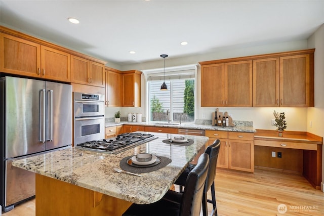 27309 SE 10th Ct, Sammamish, WA 98075 - kitchen featuring stainless steel appliances, a sink, light stone counters, light wood finished floors, and recessed lighting