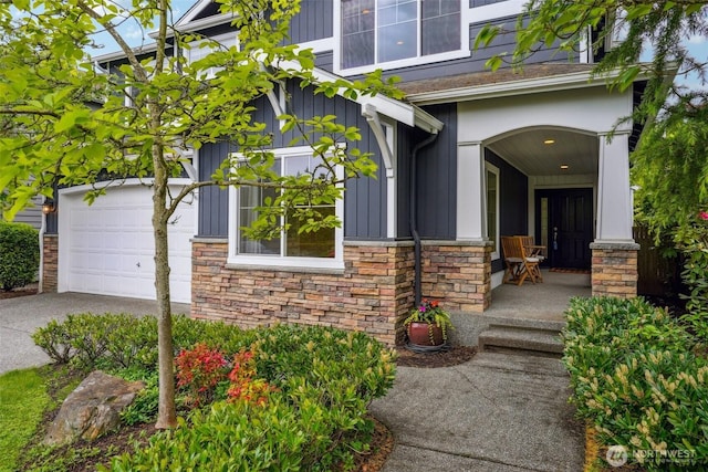 27309 SE 10th Ct, Sammamish, WA 98075 - view of exterior entry with stone siding, board and batten siding, concrete driveway, and covered porch