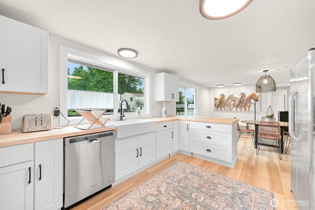 1005 Johnson St, Sumas, WA 98295 - kitchen featuring stainless steel appliances, a sink, wood counters, light wood finished floors, and white cabinetry