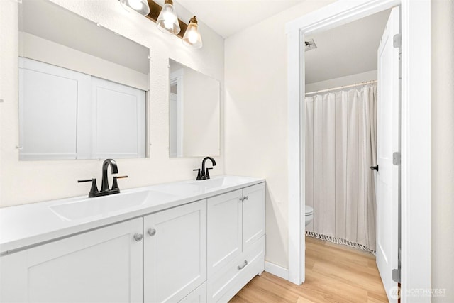1005 Johnson St, Sumas, WA 98295 - bathroom with toilet, wood finished floors, double vanity, and baseboards