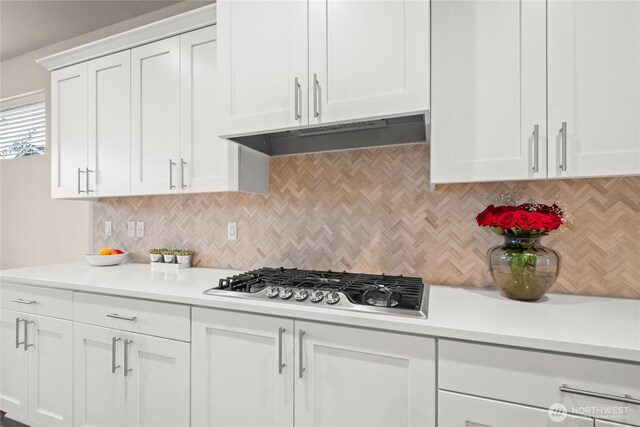 1009 NE 13th St, Battle Ground, WA 98604 - kitchen with stainless steel gas cooktop, under cabinet range hood, light countertops, tasteful backsplash, and white cabinets