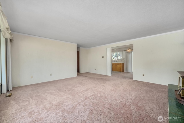 2815 NE Wyoming St, Bremerton, WA 98310 - unfurnished living room featuring carpet, a chandelier, and ornamental molding