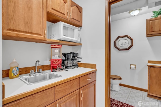 303 N B St, Roslyn, WA 98941 - kitchen featuring white microwave, a sink, light countertops, light floors, and baseboards