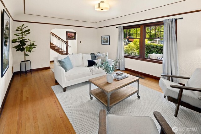 116 E Edgar St, Seattle, WA 98102 - living area featuring light wood finished floors, arched walkways, baseboards, and stairway