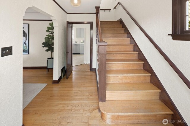 116 E Edgar St, Seattle, WA 98102 - stairs featuring a textured wall, wood finished floors, arched walkways, ornamental molding, and baseboards