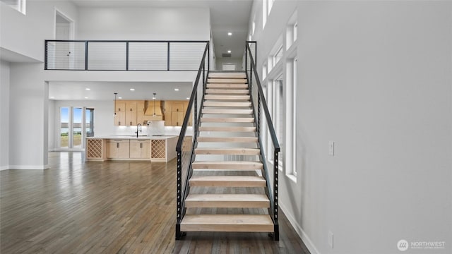 6988 Stonecrest Rd NE, Moses Lake, WA 98837 - staircase featuring wood finished floors, baseboards, a towering ceiling, and recessed lighting