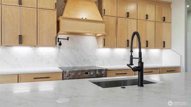 6988 Stonecrest Rd NE, Moses Lake, WA 98837 - kitchen featuring premium range hood, a sink, light stone counters, and backsplash