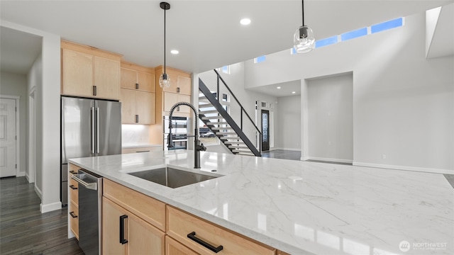 6988 Stonecrest Rd NE, Moses Lake, WA 98837 - kitchen featuring light brown cabinets, a sink, baseboards, decorative light fixtures, and light stone countertops