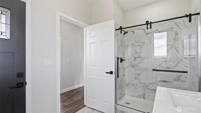 6988 Stonecrest Rd NE, Moses Lake, WA 98837 - bathroom featuring a marble finish shower, wood finished floors, a sink, and baseboards