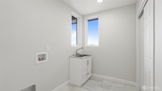6988 Stonecrest Rd NE, Moses Lake, WA 98837 - washroom featuring baseboards, hookup for a washing machine, light marble finish floors, and cabinet space