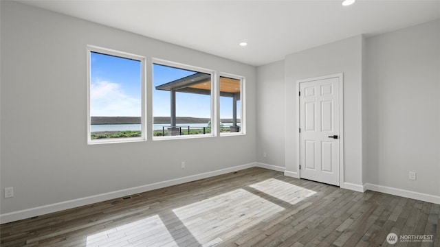 6988 Stonecrest Rd NE, Moses Lake, WA 98837 - unfurnished bedroom featuring dark wood finished floors, baseboards, recessed lighting, and a water view