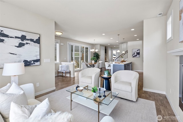 938 SW 97th St, Seattle, WA 98106 - living room with wood finished floors, a chandelier, baseboards, recessed lighting, and stairs