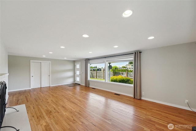 1012 9th Ave N, Edmonds, WA 98020 - unfurnished living room with light wood-style flooring, recessed lighting, baseboards, and a fireplace with flush hearth