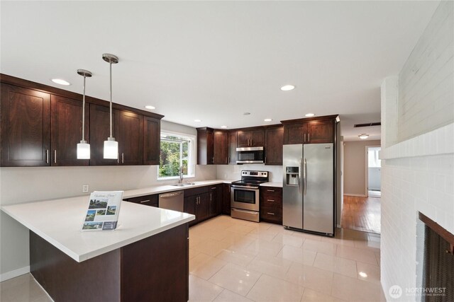 1012 9th Ave N, Edmonds, WA 98020 - kitchen with appliances with stainless steel finishes, a sink, dark brown cabinetry, light countertops, and a peninsula