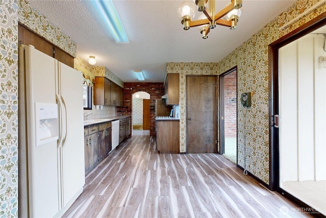 1220 Valley Vista Ave, Walla Walla, WA 99362 - kitchen with white appliances, wallpapered walls, light wood-style floors, a chandelier, and a textured ceiling