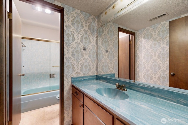 1220 Valley Vista Ave, Walla Walla, WA 99362 - full bath featuring wallpapered walls, vanity, a textured ceiling, combined bath / shower with glass door, and toilet
