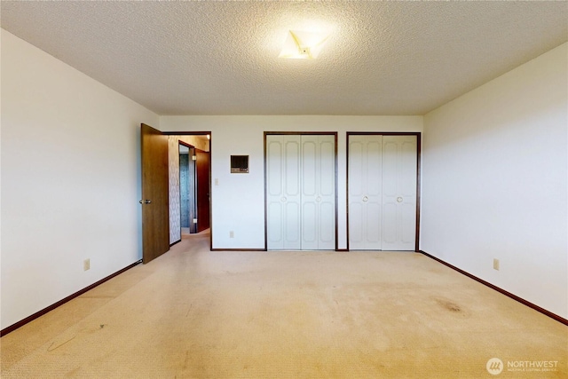1220 Valley Vista Ave, Walla Walla, WA 99362 - unfurnished bedroom featuring multiple closets, light carpet, baseboards, and a textured ceiling
