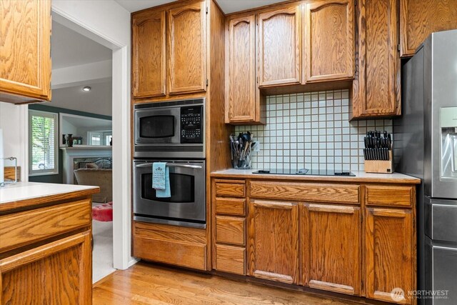 16605 71st Pl W, Lynnwood, WA 98037 - kitchen featuring appliances with stainless steel finishes, light countertops, light wood finished floors, and tasteful backsplash