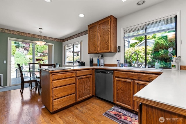 16605 71st Pl W, Lynnwood, WA 98037 - kitchen with stainless steel dishwasher, a sink, a peninsula, brown cabinets, and healthy amount of natural light
