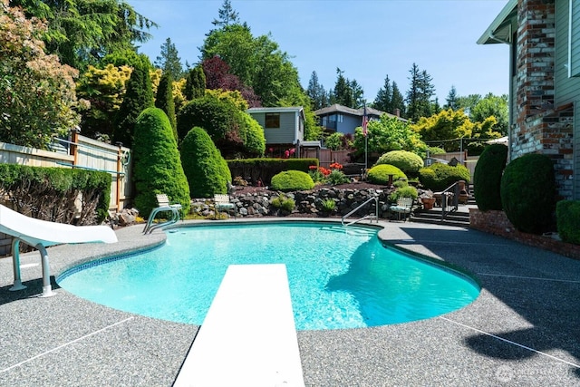 16605 71st Pl W, Lynnwood, WA 98037 - outdoor pool with a diving board, a water slide, a fenced backyard, and a patio area