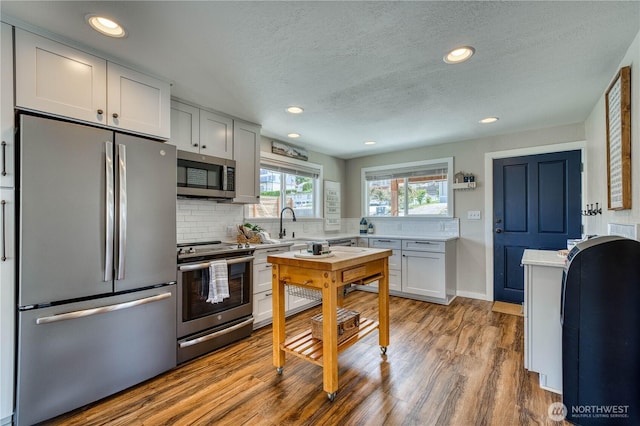 421 Lakeview Dr, Orondo, WA 98843 - kitchen with stainless steel appliances, light countertops, tasteful backsplash, wood finished floors, and a textured ceiling