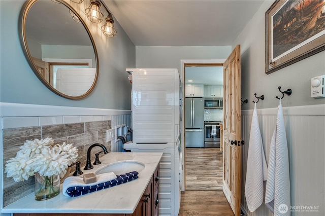 421 Lakeview Dr, Orondo, WA 98843 - bathroom with wood finished floors, a wainscoted wall, vanity, and backsplash