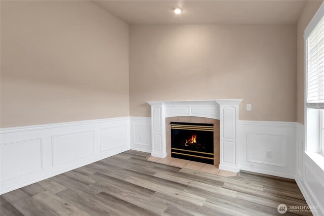 15127 148th Avenue Ct E, Orting, WA 98360 - detailed view of wainscoting, a fireplace, wood finished floors, and a decorative wall