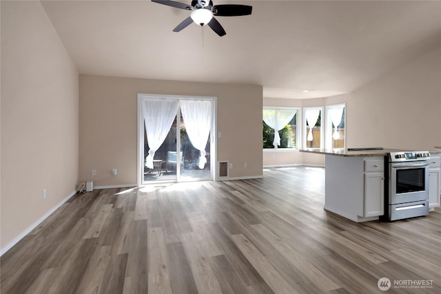15127 148th Avenue Ct E, Orting, WA 98360 - kitchen with stainless steel range with electric stovetop, open floor plan, white cabinets, wood finished floors, and ceiling fan