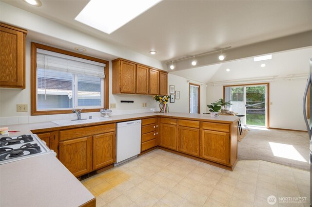 3901 Sterling Pl, Anacortes, WA 98221 - kitchen featuring dishwasher, a sink, a peninsula, light countertops, and vaulted ceiling