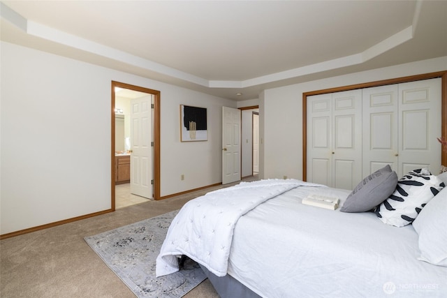 3901 Sterling Pl, Anacortes, WA 98221 - bedroom with a tray ceiling, light carpet, a closet, baseboards, and ensuite bath