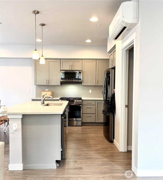 18901 12th Pl W Unit A1, Lynnwood, WA 98036 - kitchen featuring appliances with stainless steel finishes, gray cabinetry, a wall mounted AC, light countertops, and light wood-style flooring