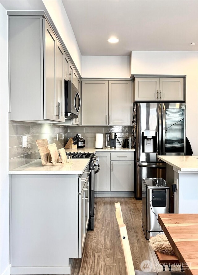18901 12th Pl W Unit A1, Lynnwood, WA 98036 - kitchen with gray cabinets, stainless steel appliances, light countertops, wood finished floors, and backsplash