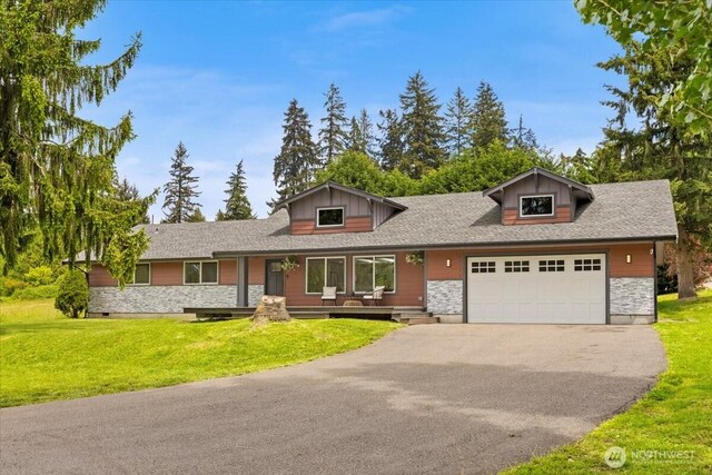 12125 E Woodland Ave, Puyallup, WA 98373 - view of front of home with stone siding, driveway, a garage, and a front yard