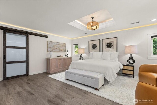 12125 E Woodland Ave, Puyallup, WA 98373 - bedroom featuring a chandelier, multiple windows, a raised ceiling, wood finished floors, and recessed lighting