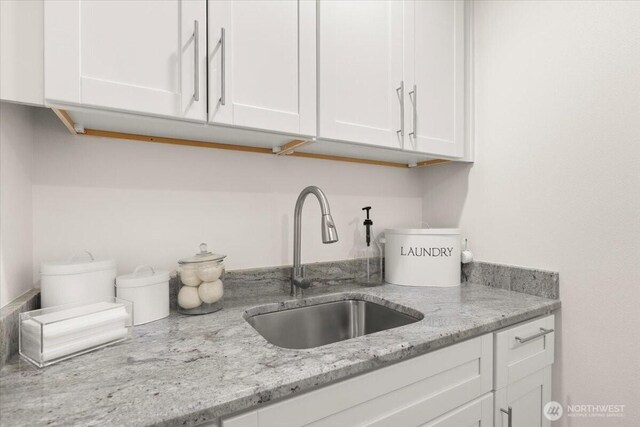 12125 E Woodland Ave, Puyallup, WA 98373 - kitchen with a sink, white cabinetry, and light stone counters