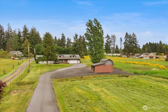 12125 E Woodland Ave, Puyallup, WA 98373 - view of property's community with asphalt driveway, an outdoor structure, and a garage