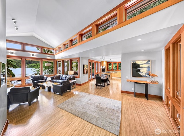 891 E Lake Samish Dr, Bellingham, WA 98229 - living area with baseboards, light wood-style floors, lofted ceiling, and a water view