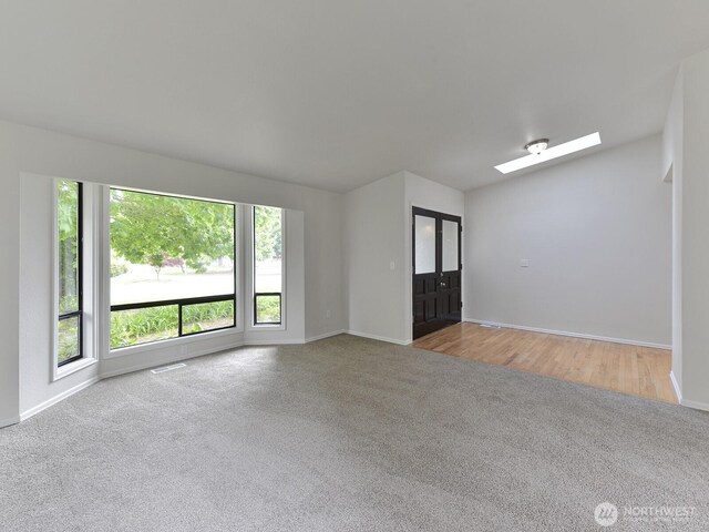 25705 117th Pl SE, Kent, WA 98030 - carpeted empty room featuring a skylight, baseboards, and vaulted ceiling