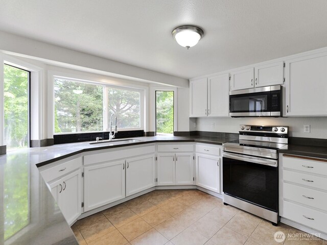 25705 117th Pl SE, Kent, WA 98030 - kitchen featuring appliances with stainless steel finishes, a sink, light tile patterned flooring, white cabinets, and dark countertops