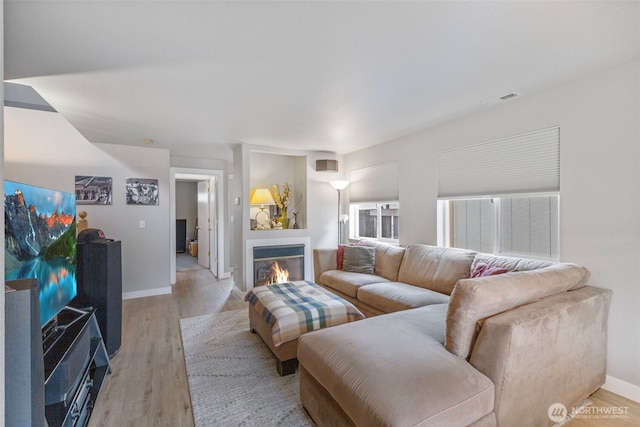 125 99th Street Ct E, Tacoma, WA 98445 - living area featuring a glass covered fireplace, light wood finished floors, and baseboards