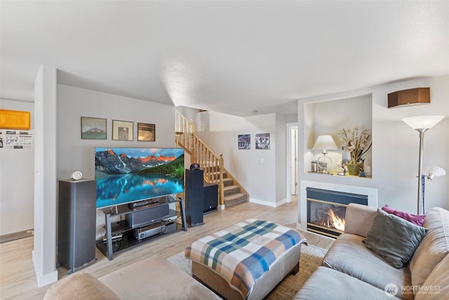 125 99th Street Ct E, Tacoma, WA 98445 - living room featuring a tiled fireplace, stairs, light wood-type flooring, and baseboards